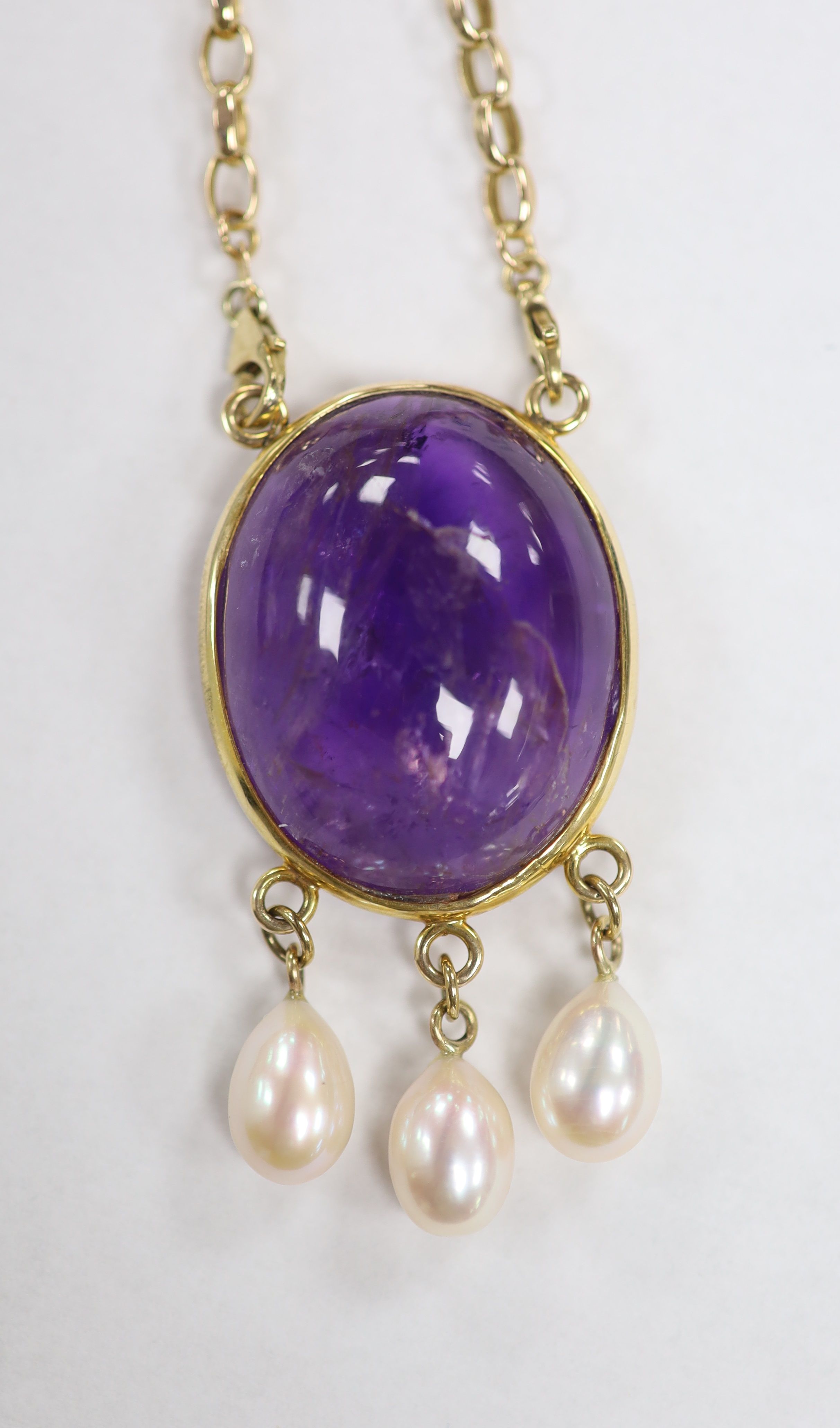 A modern yellow metal mounted, oval amethyst pebble and three stone cultured pearl set drop pendant, 66mm, on a 9ct gold chain